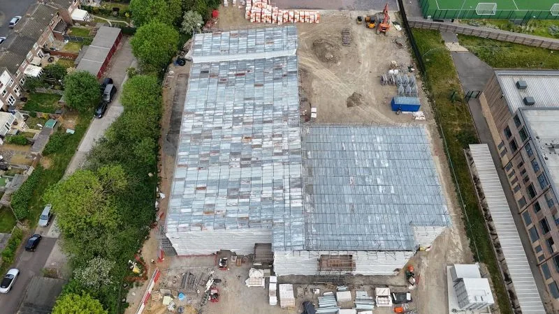 Top-down aerial of both completed temporary roofs with sheeted elevations and site compound